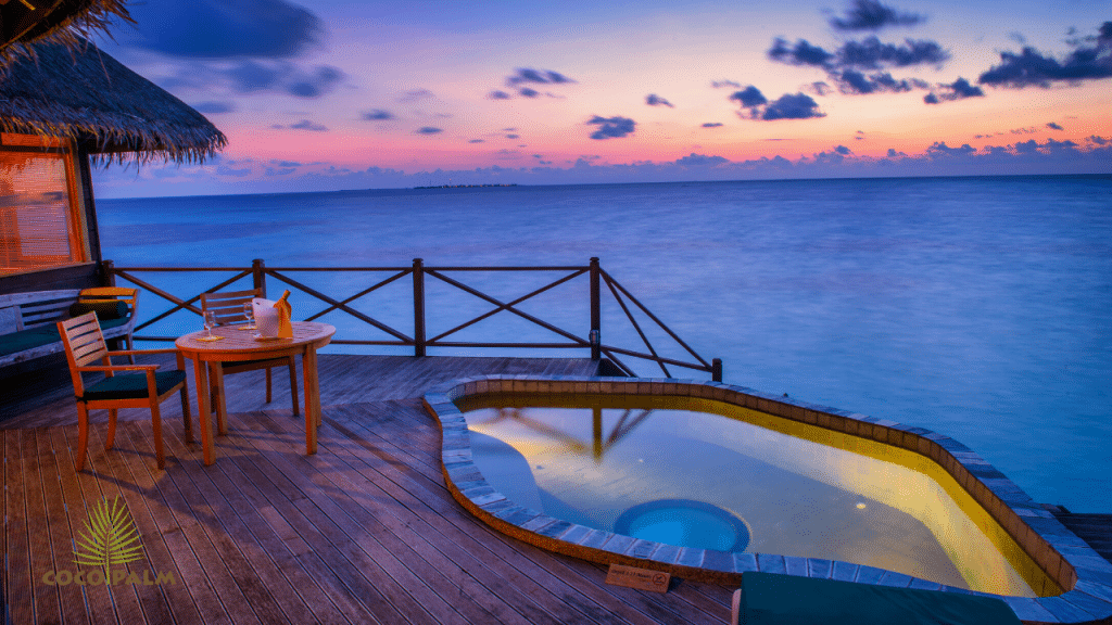 A sunset picture in the ocean. Shows a cabana and hottub during sunset