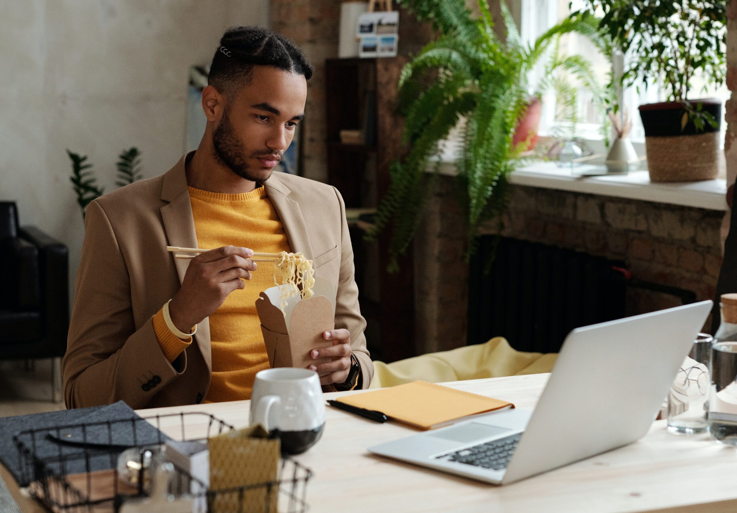 Individual working from home, while eating noodles.