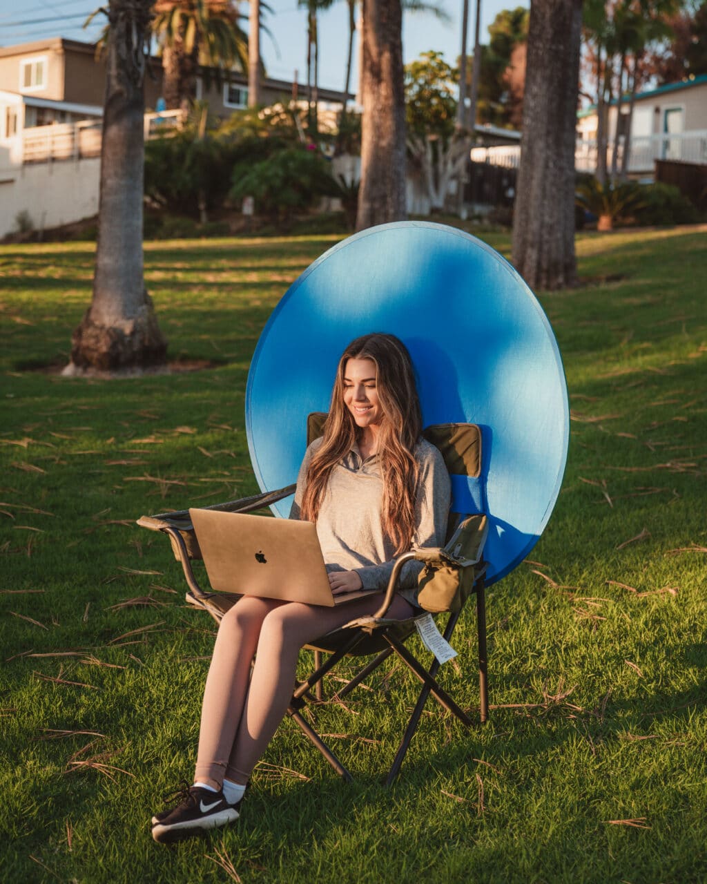 Woman sitting outside using a portable green screen - Webaround